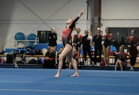 A member on the girls gymnastics team does a routine. 