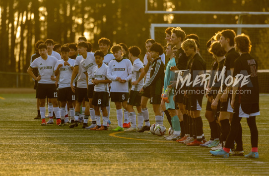 PHS boys soccer team stand on the sidelines. 