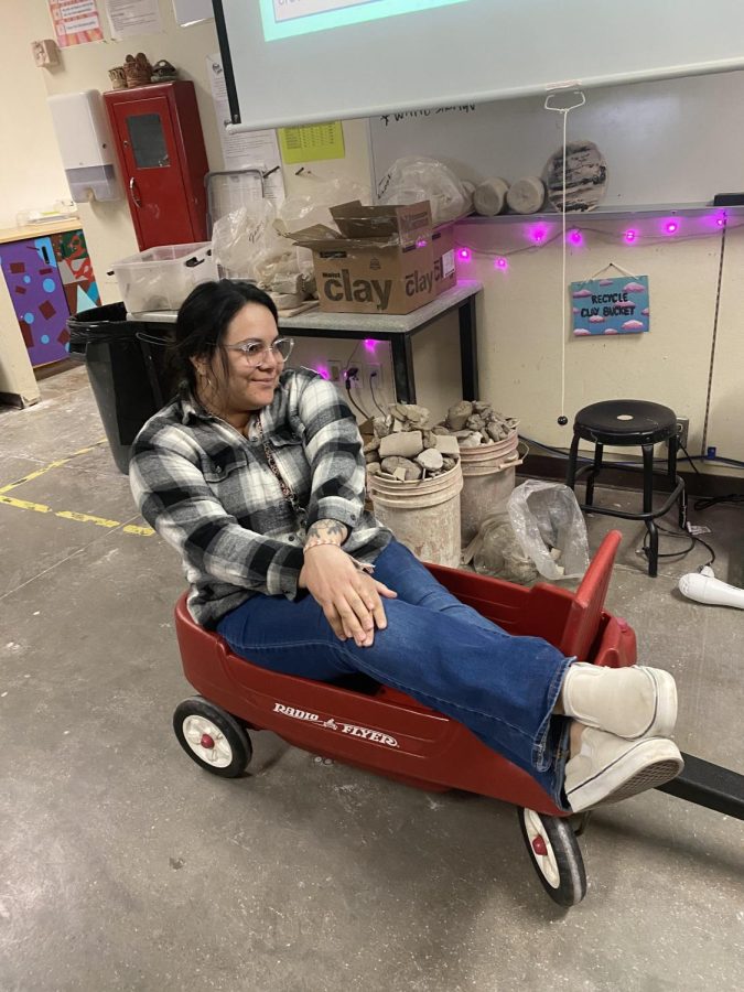 Ms. Stevens, the ceramics teacher, rides in a wheel barrow someone brought for anything but a backpack day. 