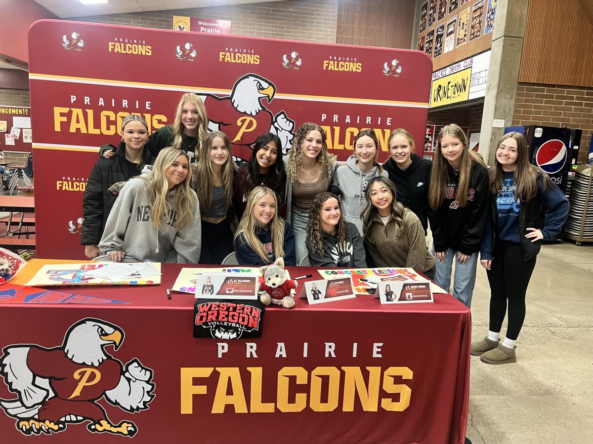 Soccer seniors Maddie Thorsen and Kate Durfey surrounded by friends and teammates after signing their commitments to play college soccer.