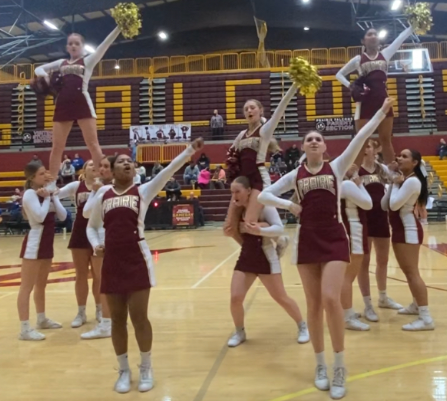 Prairie Cheer striking a pose while hyping up the crowd during a quarter-break on the sidelines of a home basketball game.