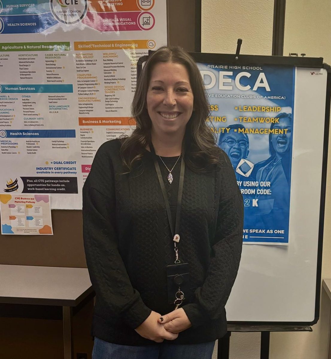 Mrs. Engelbart in front of her club sign, DECA