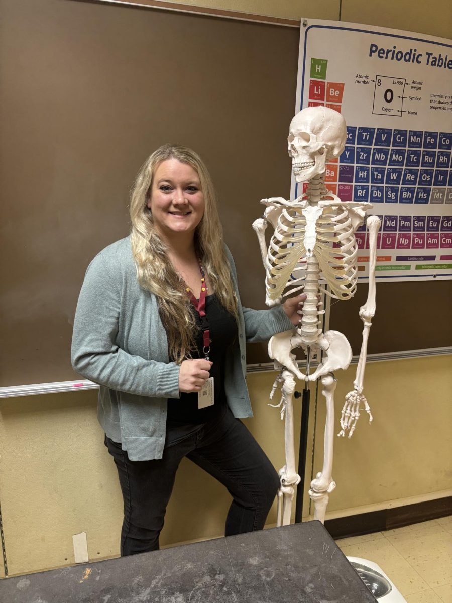 Rachel Reid with Skully the Skeleton in her anatomy classroom.