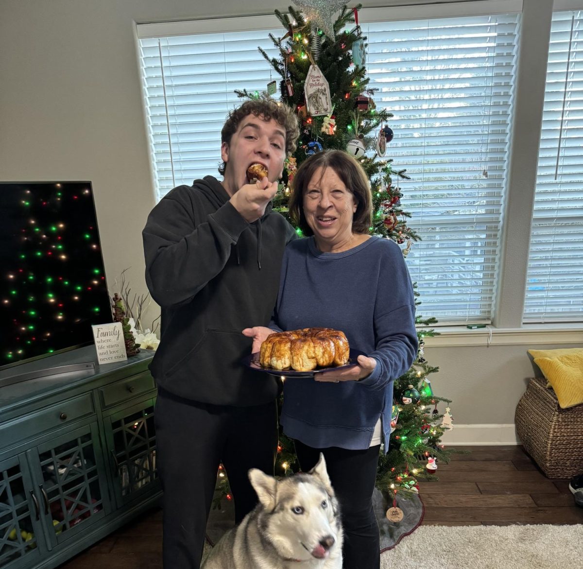 Senior Kaleb Cave pose’s with his grandma as he devours one of her homemade cinnamon rolls