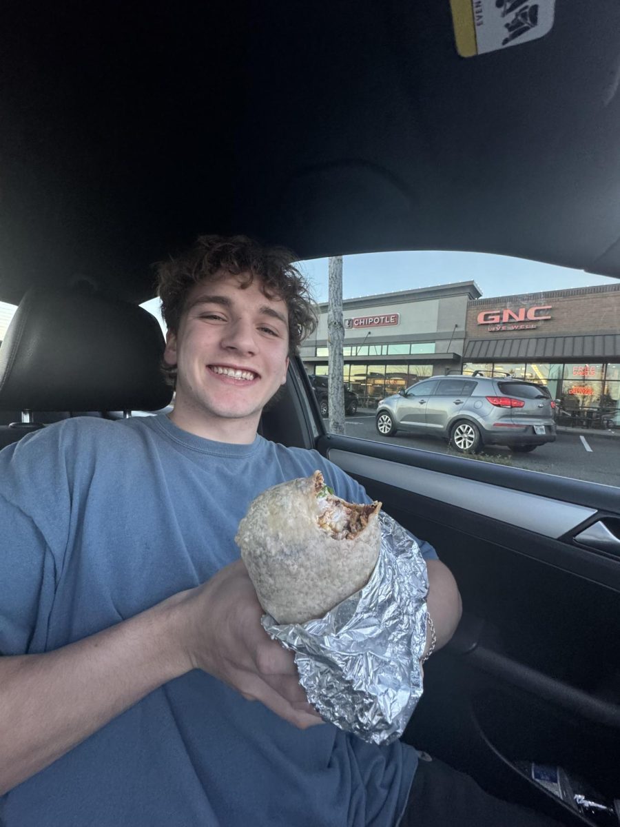 Senior Kaleb Cave shows off his brisket burrito outside the Hazel Dell Chipotle.