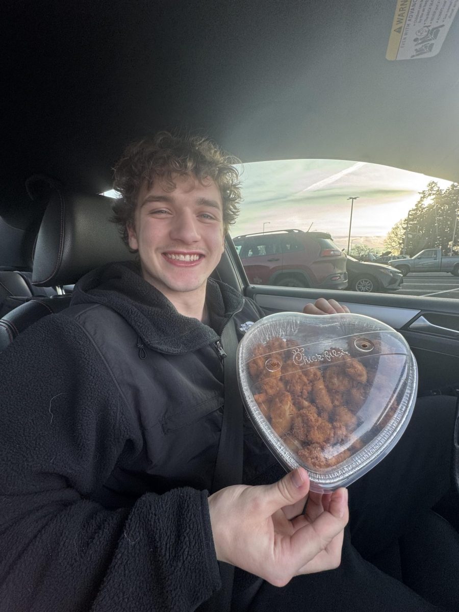 Senior Kaleb Cave holds up a 30 count nugget from Chick-fil-A in the limited time heart tray.