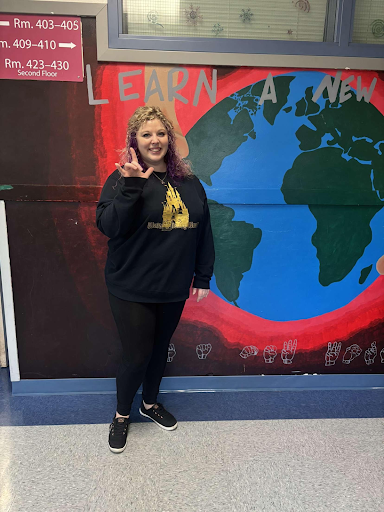 Keary Niarkos signing “I love you“ in ASL outside her classroom. 