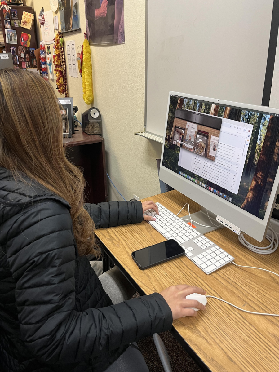 With determination, Ava works on promoting the baby senior photos for the yearbook.
