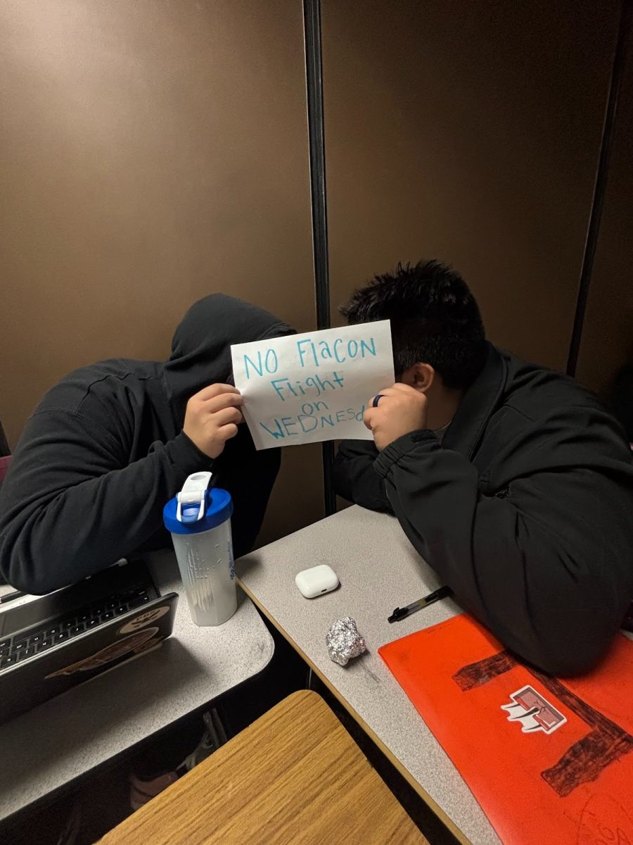 Two students at Prairie high school holding up a sign about no flight time on Wednesday anymore.
