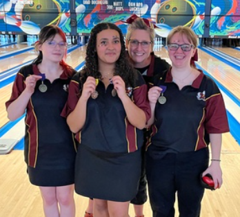 Ronda Bash and the 3 girls who qualified for state, holding their state  qualifying medals up.
