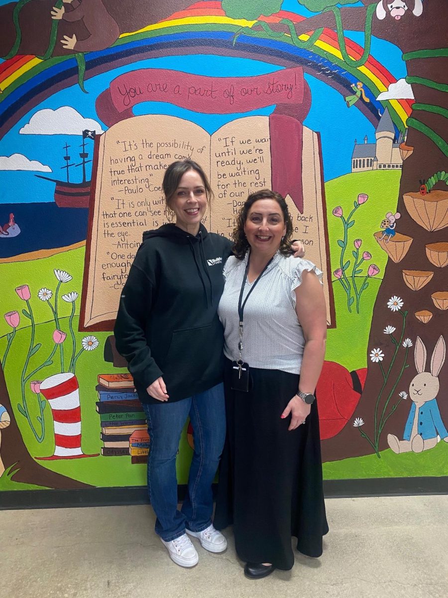 Lauren Lavender and Robin Brennan in front of the library mural.
